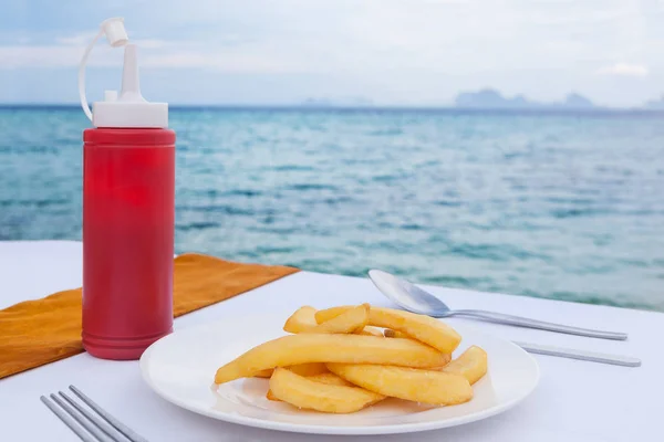 French fries on with ketchup on table in ocean view restaurant in Thailand, Asia. Tropical travel.