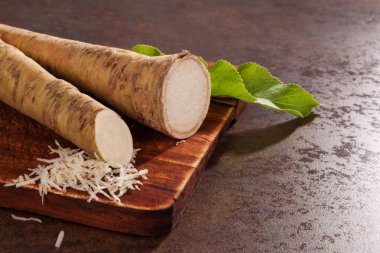 Taze ve rendelenmiş horseradish kök grunge arka plan üzerinde.