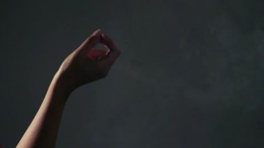 Karanlık odada iki el arasında esrar ortak geçen.