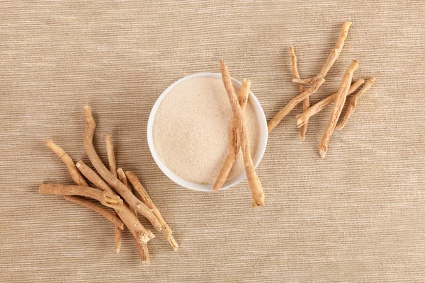 Ashwagandha kök ve toz ek, üstten görünüm.