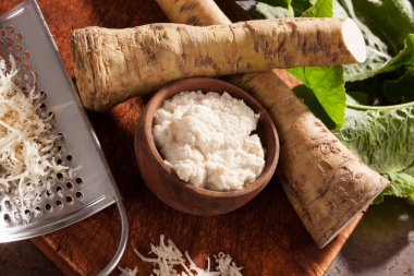 Taze ve rendelenmiş horseradish yapraklarda yukarıdan ahşap arka plan ile. Sağlıklı sebze.