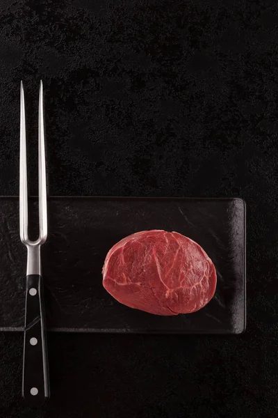 Bifteck Boeuf Cru Avec Fourchette Viande Sur Une Tresse Noire — Photo gratuite