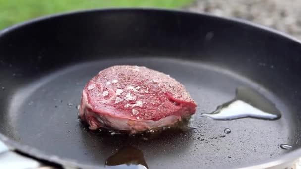スパイスと油でフライパンでおいしい生のステーキ — ストック動画
