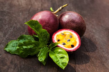 Ahşap masa yapraklarda ile mor tutku meyve. Passiflora mantarı.