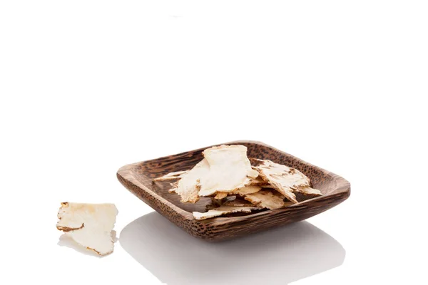 当归根在木碗被隔绝在白色背景 传统药用草药 — 图库照片