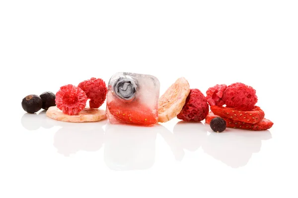 Freeze dried strawberries, raspberries, currants, blueberries and banana and berries frozen in ice cubes isolated on white background.