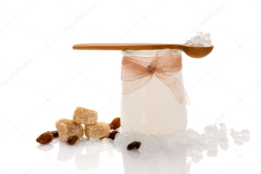 Tibi crystal, tibicos, sugar kefir grains in glass with sugar and dry fruit isolated on white background.