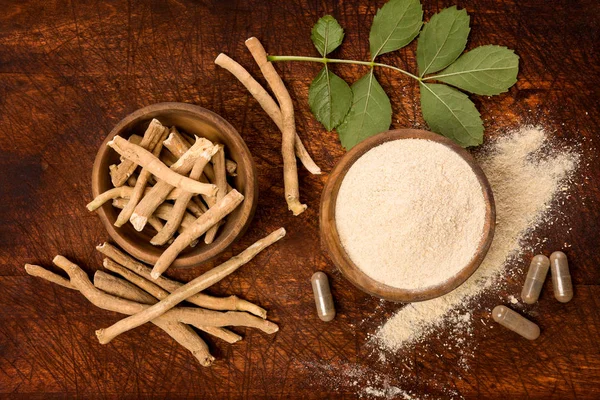 Ashwagandha superfood toz ve kök yukarıdan ahşap masa üzerinde kesme tahtası üzerinde. Adaptogen.