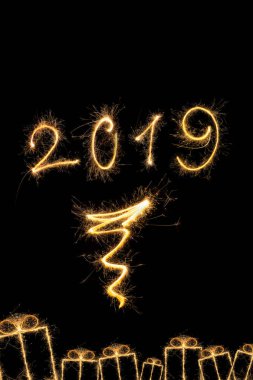 Mutlu yeni yıl 2019. 2019 numaraları ve siyah arka plan üzerine izole Noel hediyeleri oluşturan sihirli havai fişek. 