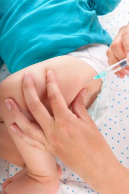 Erkek bir bebek veren çocuk doktoru kas içi enjeksiyon. Tıp kavramı.
