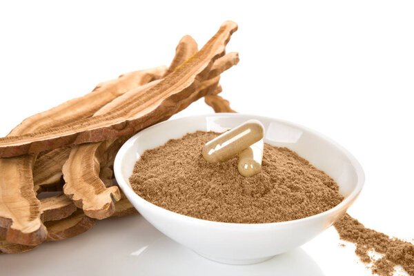 Сушеные грибы рейши с порошком и гелевыми капсулами изолированы на белом фоне
.