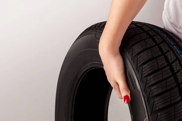 Woman hand holding car tire.