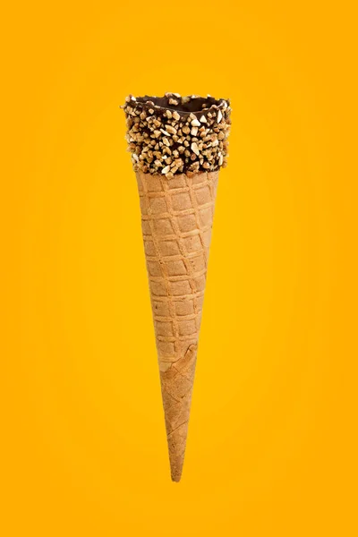 Cone vazio com nozes e chocolate em um fundo amarelo com um — Fotografia de Stock