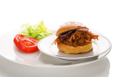 Hamburger ekmeğinde domuz eti ve taze salata..