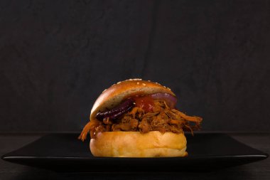 Siyah tabakta siyah arka planda domuz burgeri..