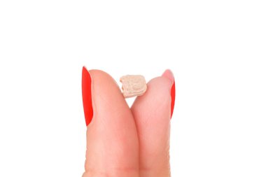 Ecstasy pill in female fingers with red nails isolated on white background. Party drug. clipart