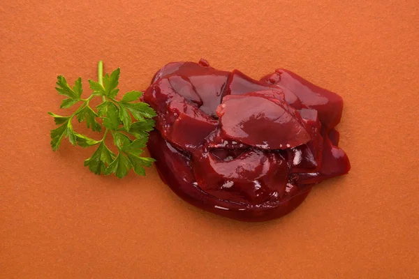 Rauwe Kippenlever Oranje Achtergrond Versierd Met Kruidenpeterselie Voedselingrediënt — Stockfoto