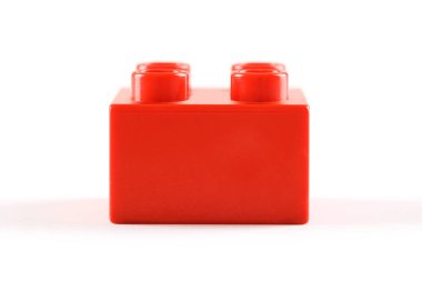 Beyaz arka planda kırmızı plastik lego / duplo bloğu. Basitlik kavramı ve çocukların yaratıcılığı.