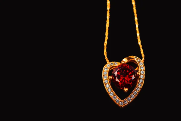 Gold pendant with a ruby on a black background — Stock Photo, Image