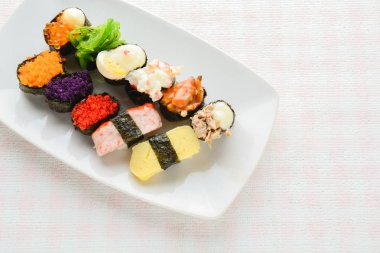 Beyaz tabakta suşi, ton balığı, somon, levrek, tatlı yumurta, karides 