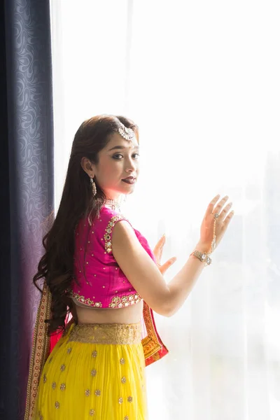 Рожевий і жовтий індійський костюм красивою дівчиною, обличчя частково Ко — стокове фото