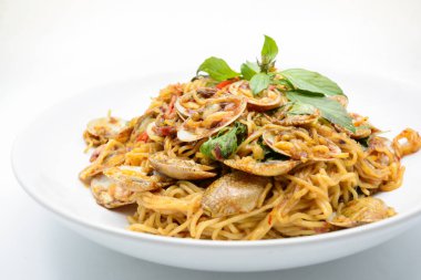 Kızarmış erişteyi midye ve otla karıştır, sıcak ve baharatlı.