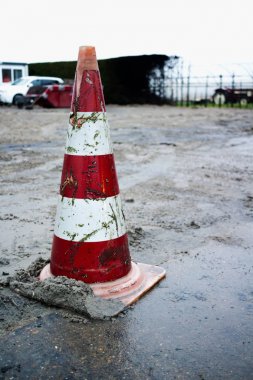 Parlak kırmızı ve kirli trafik konisi yangın sonuçları arka planda çamur ayakta
