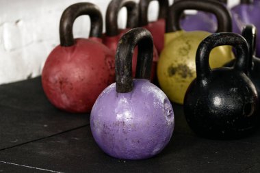 Spor aletleri. Çelik ağırlık ve parlak kettlebells siyah kauçuk zemin üzerinde durmak.