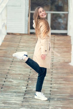 Pozitif zihin ve huzur. Sahilde ahşap tahta üzerinde bacak kaldırdı gülümseyen genç kadın