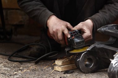 Disk öğütücü. Atölyede açı öğütücü ile çelik kesme bir işçi, kıvılcım yanlara sinek.