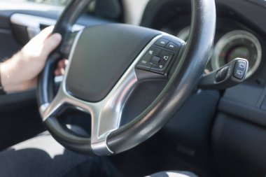 Arabayı kullanan adam, sol elini tutan direksiyon
