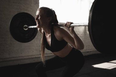 Barbell ile çömelmiş yapan fit genç kız. Çapraz eğitim egzersiz.