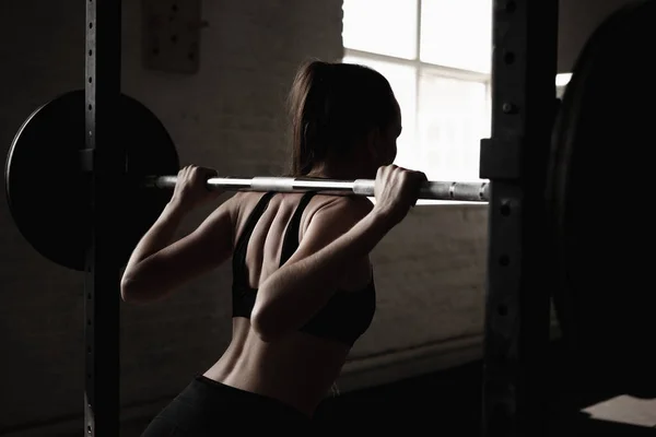 有魅力的年轻运动女性正在健身房锻炼 交叉配合训练 肌肉发达的女人蹲着杠铃 — 图库照片
