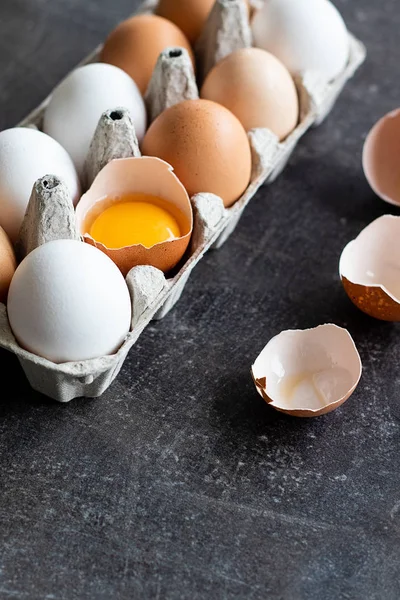 Stock image Fresh organic raw eggs, white, beige and brown, one is cracked