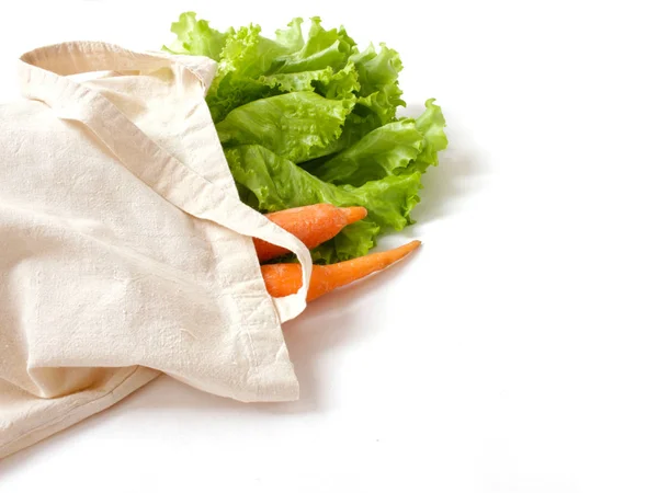 Hojas de lechuga y zanahorias frescas de naranja en una bolsa de lino para ir de compras, los mejores ingredientes para ensalada vegetariana fresca — Foto de Stock