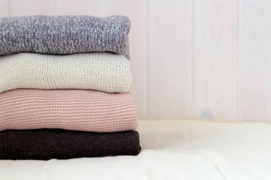 ahşap bir duvar b bir keten yastık üzerinde örme kazak bir yığın