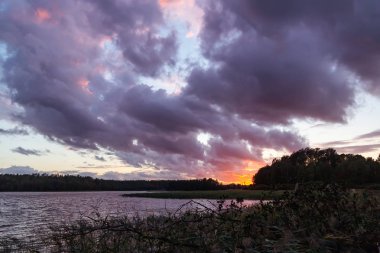 Gölde güzel renkli bir gün batımı, dramatik bulutların arasından gün ışığı, yaz akşamı manzarası - fotoğraf, görüntü