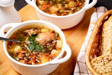 İki tabak mercimek çorbası ve siyah masadaki tahta tahtada tavuk.