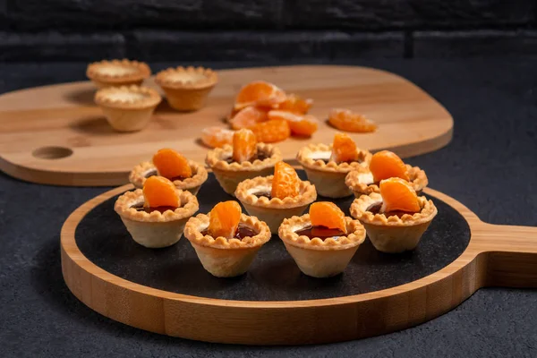 Çikolatalı turtalar ve mandalina dilimleri. Bir tabak doğal servis için.