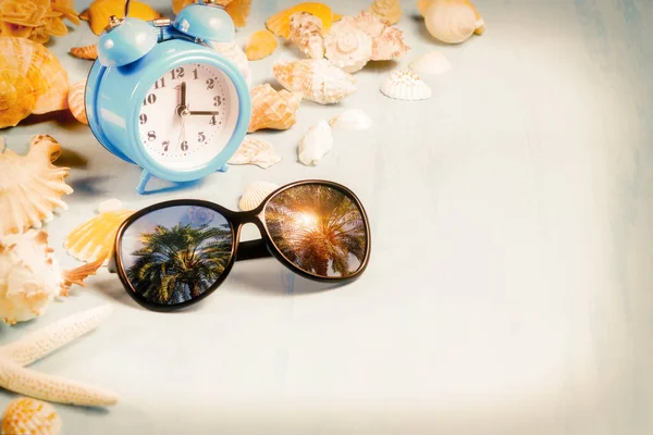 Fundo com despertadores, óculos de sol e conchas, férias de verão e conceito de tempo de férias — Fotografia de Stock