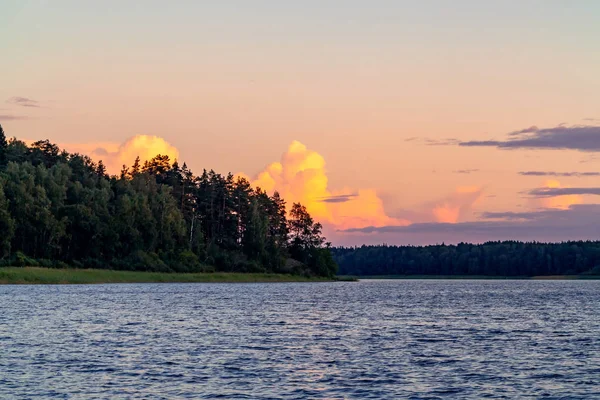 В летний день над озером на закате тучи — стоковое фото