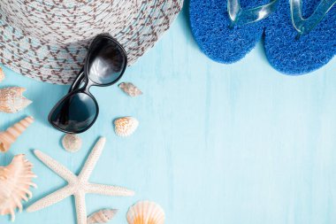 Şapka, güneş gözlüğü ve deniz kabukları, yaz tatili ve tatil saati kavramı ile mavi deniz arka plan