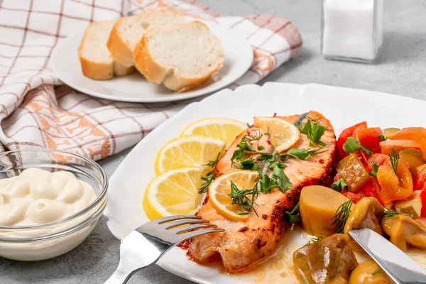 Medallón de filete de salmón al horno con ensalada de verduras en escabeche y champiñones en un plato blanco sobre un fondo gris — Foto de Stock