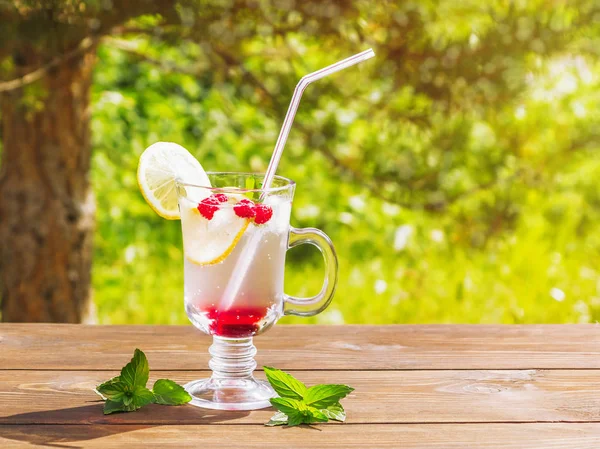 Освежающий летний коктейль с лимоном, малиной и мятой деревянный стол — стоковое фото