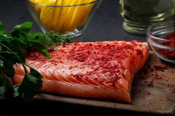 Piece of salmon fillet on a wooden cutting board with ingredients for its further preparation - photo, image — Stock Photo, Image