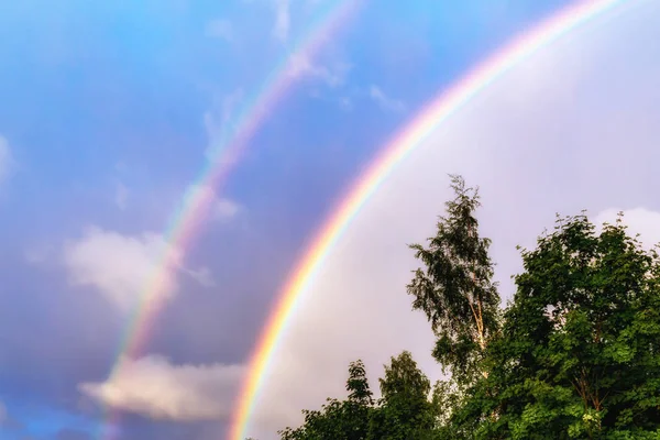 Regnbåge efter regn i en molnig himmel bland dramatiska moln — Stockfoto