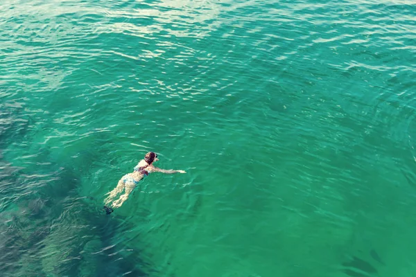 Menina mergulha com uma máscara enquanto nada na água do mar azul-turquesa do Golfo de Omã — Fotografia de Stock