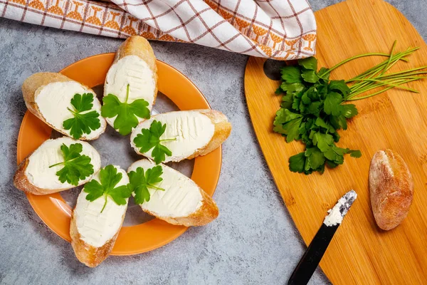 Frissen készült szendvicsek krémsajttal tányéron, szürke asztalon, felülnézet — Stock Fotó