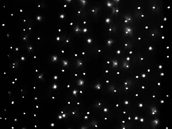Defokussierte Lichter von Weihnachtsgirlanden in Schwarz und Weiß gleichmäßig über die Fläche des Rahmens verteilt, Hintergrund, Textur — Stockfoto