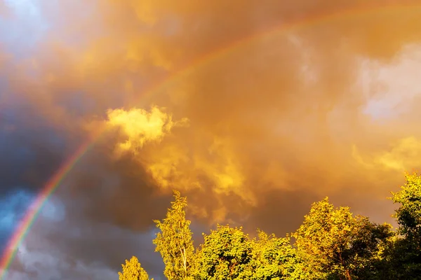 Regnbåge efter regn i en molnig himmel bland dramatiska moln — Stockfoto